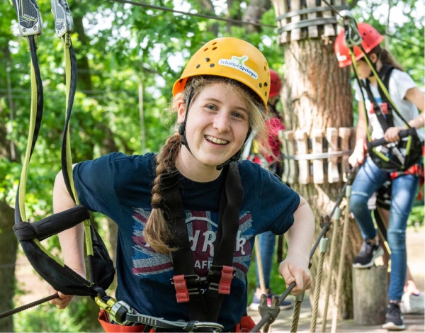 Junges Mdchen im Halbportrt mit Helm und Sicherung lchelt in die Kamera